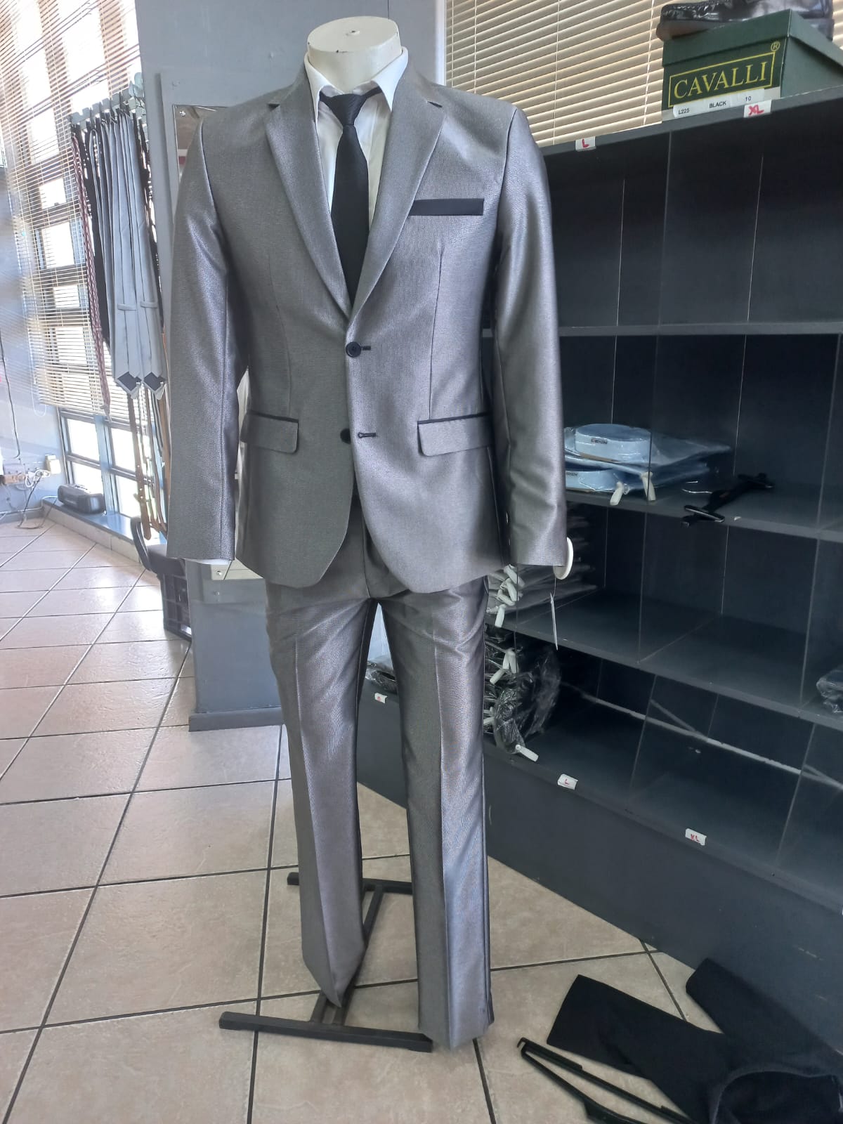 Tailored Luxxe suit displayed on a showroom mannequin
